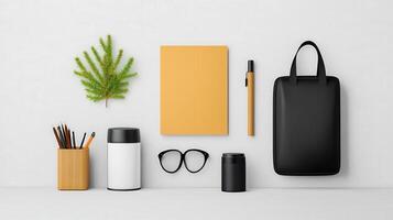 A white background with a black bag, a notebook, a pen, a cup, a pair of glasses photo