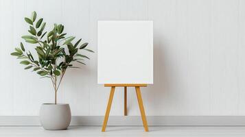 A white canvas is propped up on a wooden stand in front of a potted plant photo