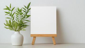 A white square frame with a white background and a green plant in a white vase photo