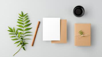 A white card with a pen and a leaf on it photo