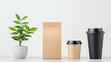 A plant sits next to a brown paper bag and a black coffee cup photo