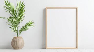 A white framed picture sits on a white wall next to a plant photo