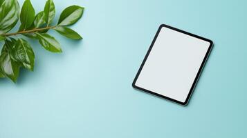 A tablet is sitting on a table next to a leaf photo