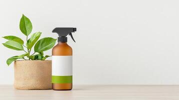 A bottle of spray sits next to a plant in a pot photo