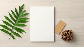 A white piece of paper sits on a wooden table with a leaf and a pinecone photo