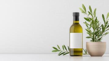 A bottle of olive oil sits on a table next to a potted plant photo