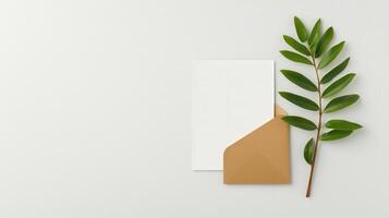 A white envelope sits on a table next to a leaf photo