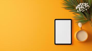 A tablet and a mug of coffee sit on a yellow background photo