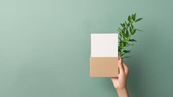 A person is holding a brown box with a white card inside photo
