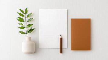 A white notebook sits on a table next to a pencil and a potted plant photo