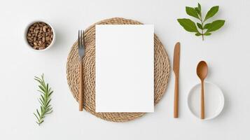 A white paper with a fork and knife on a table with a bowl of nuts and a spoon photo