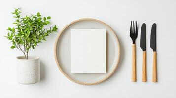 A white plate with a fork and knife on it and a white piece of paper photo