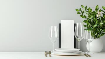 A white table with a white plate, two wine glasses, a fork photo