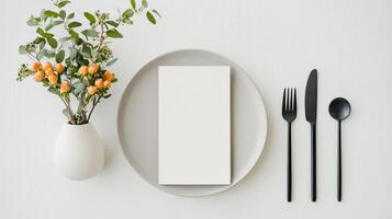 A minimalist white plate with a fork, knife, and spoon on it photo