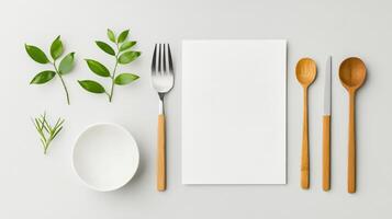 A minimal white paper with a fork, knife and spoon on it photo