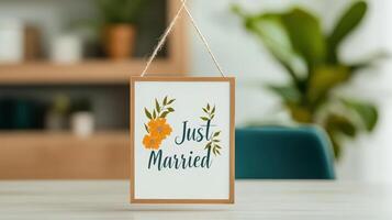 A framed sign that says Just Married sits on a table photo