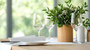 A table with a vase of flowers and four wine glasses photo