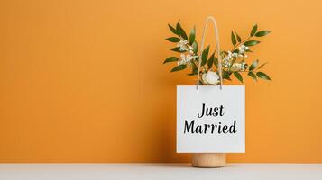 A white bag with a flower in it and the words Just Married written on it photo