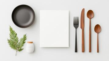 A white plate, fork, knife, and spoon are arranged on a table photo
