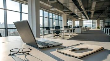 Sunlit Modern Office Desk with Laptop Notebook and Glasses photo