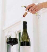 Enjoying a fine wine with a freshly opened bottle at a serene setting photo