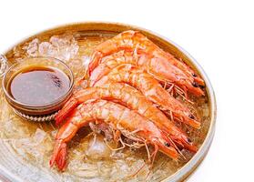 Fresh shrimp served with dipping sauce on ice platter photo