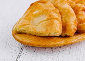 Freshly baked langos savoury deep fried flat bread on wooden plate photo