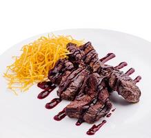 Grilled steak served with crispy potatoes and berry sauce photo