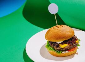 Juicy burger with cheese and fresh vegetables on a plate photo