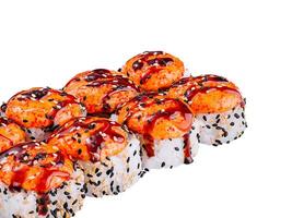 Sushi rolls topped with spicy sauce and sesame seeds photo