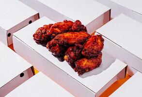 Crispy chicken wings served on a white takeout container photo