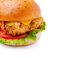 Crispy chicken sandwich with fresh toppings and sesame bun photo