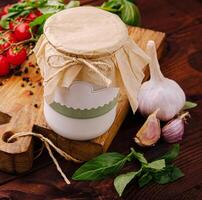 Homemade garlic sauce with fresh ingredients on a wooden table photo