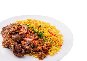 Savory meat dish served with spiced rice and fresh vegetables photo