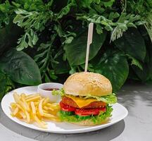 Delicious plant-based burger served with fries in a natural setting photo