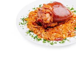 Savory pork knuckle served on a bed of cabbage and herbs photo
