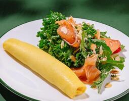 Savory crepe served with fresh salad and smoked salmon photo