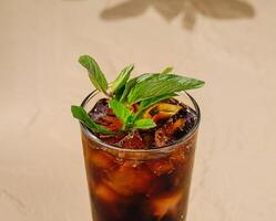 Refreshing ice cold cola with mint leaves on a table photo