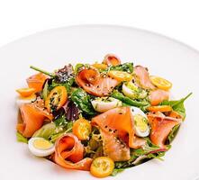 Fresh salad with smoked salmon, quail eggs, and cherry tomatoes photo