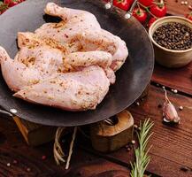 Freshly marinated chicken ready for grilling on wooden table photo