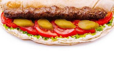 Delicious wrap with grilled meat and fresh vegetables closeup photo