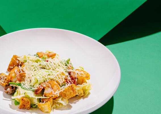 Fresh shrimp salad served in a white bowl on vibrant background