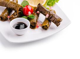Delicious stuffed grape leaves served with tangy sauce photo
