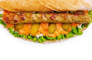 Delicious sandwich with grilled meat, fresh vegetables, and sauce photo