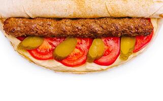 Delicious wrap with grilled meat, tomatoes, and pickles for lunch photo