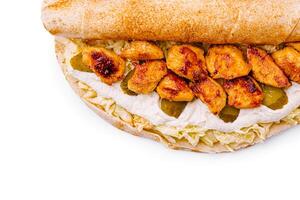 Chicken wrap with creamy sauce and pickles served on a flatbread photo