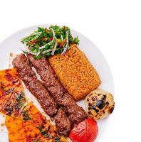 Delicious grilled kebabs with flavorful rice and fresh vegetables photo