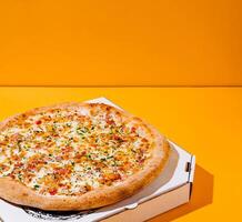 Delicious pizza on a bright orange background top view photo