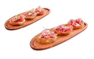Delicious tapas featuring cured ham on wooden serving boards photo