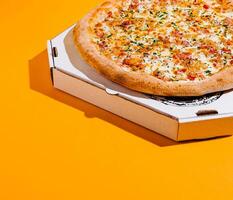 Freshly baked pizza in an open box on a bright surface photo